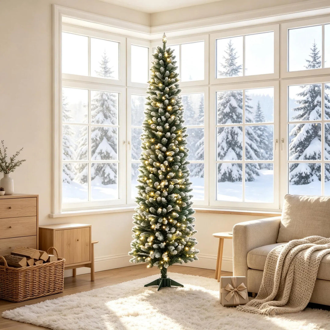 Smal frosttoppad julgran med ljus