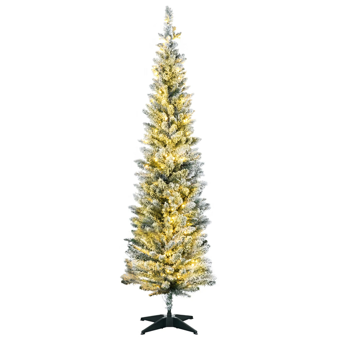 Snöig smal julgran med varma ljus