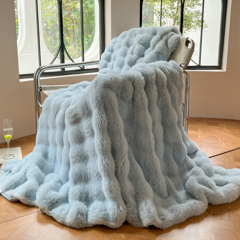Tjock pläd i bubbelplysch på soffa