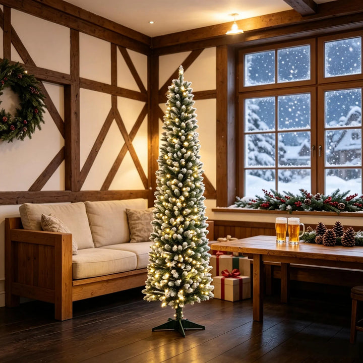 Smal frosttoppad julgran med ljus