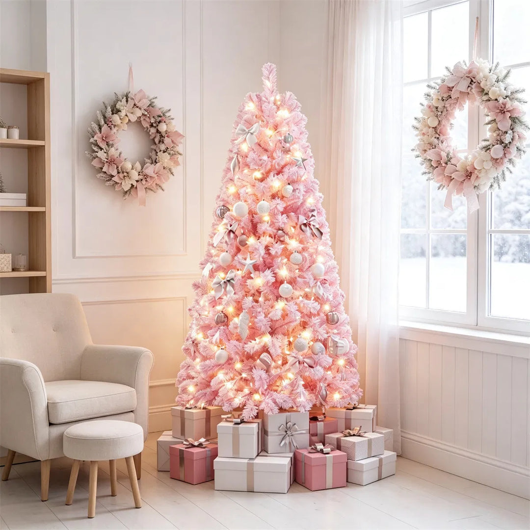 Liten rosa flockad julgran med ljus