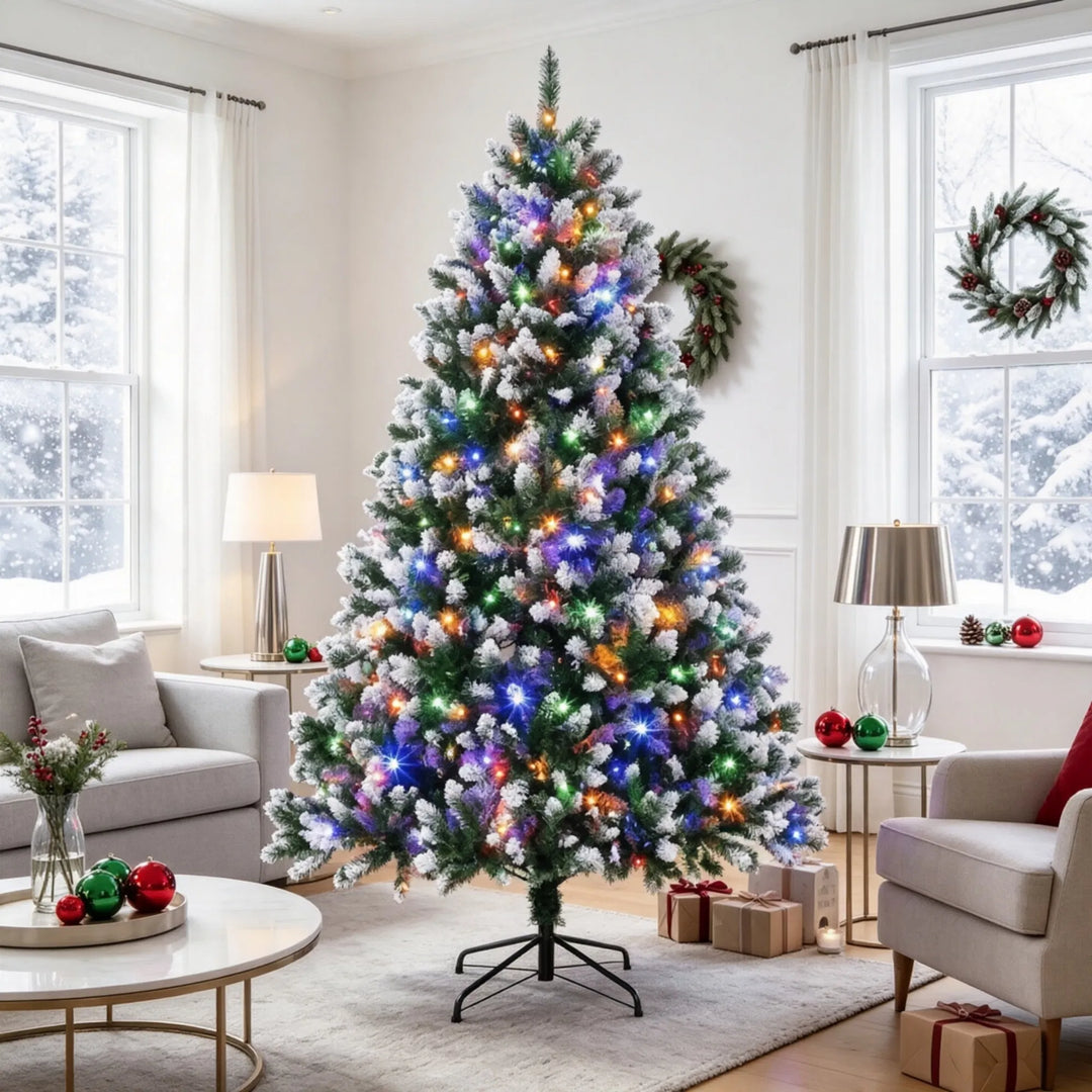 Stor snötoppad julgran med ljus