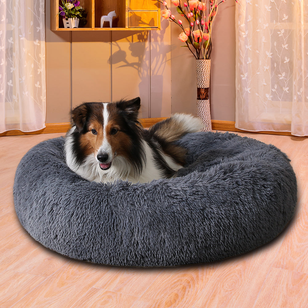 Hund ligger i fluffig rund bädd