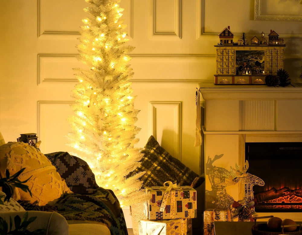 Vit smal julgran med varmvita ljus