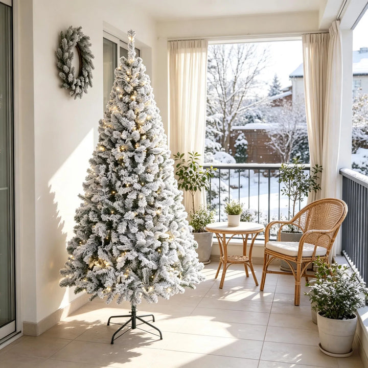 Snöflockad gran med varmvita ljus