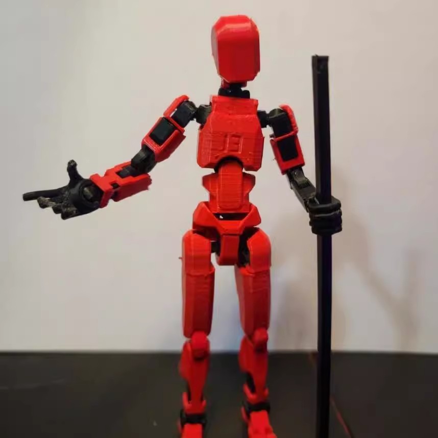 Orange 3D-printad robotfigur i pose