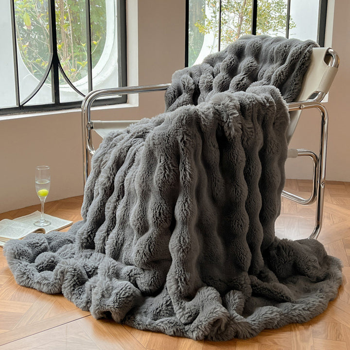 Tjock pläd i bubbelplysch på soffa