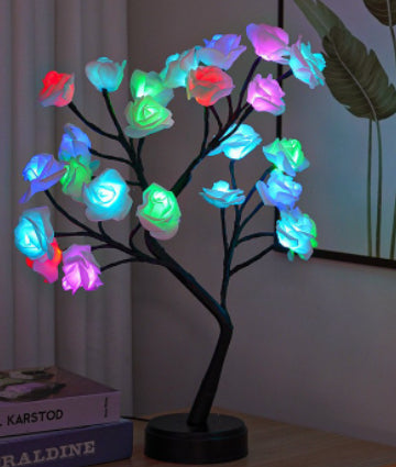 Rosenträdslampa med rosa rosor som lyser