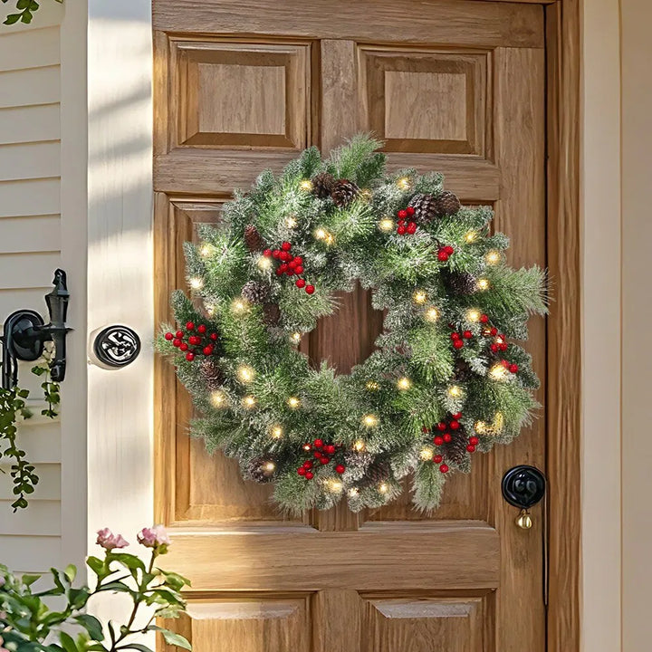 Upplyst julkrans med kottar och bär