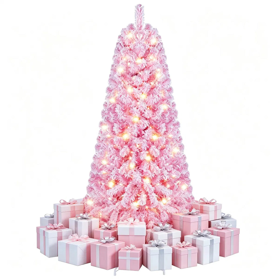 Liten rosa flockad julgran med ljus