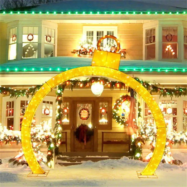 Upplyst julportal med julkulor över gången