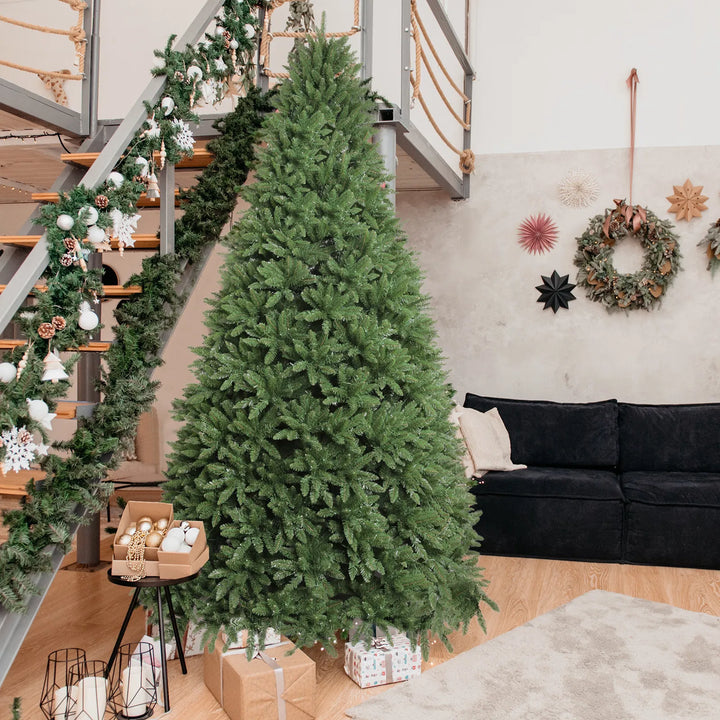 Stor upplyst julgran med varmvita och färgade lampor